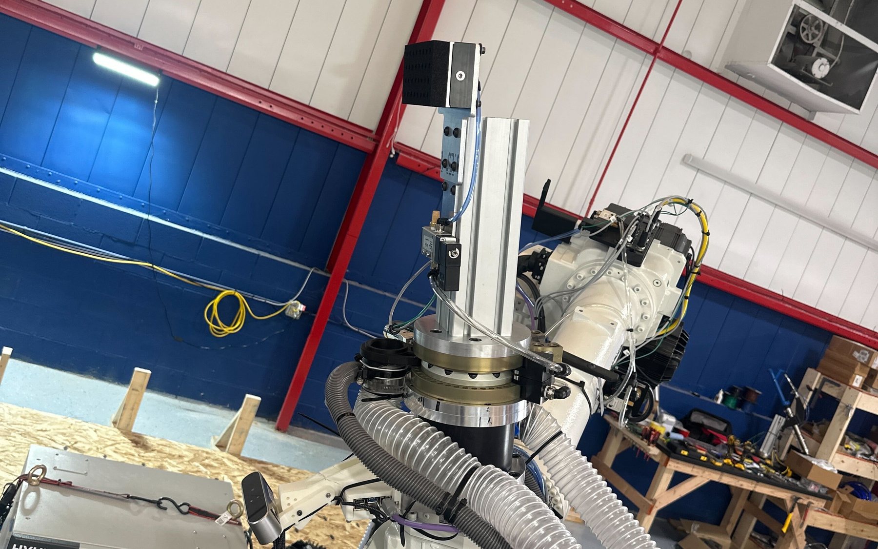 Industrial robot arm with custom end-of-arm tooling in a robot cell