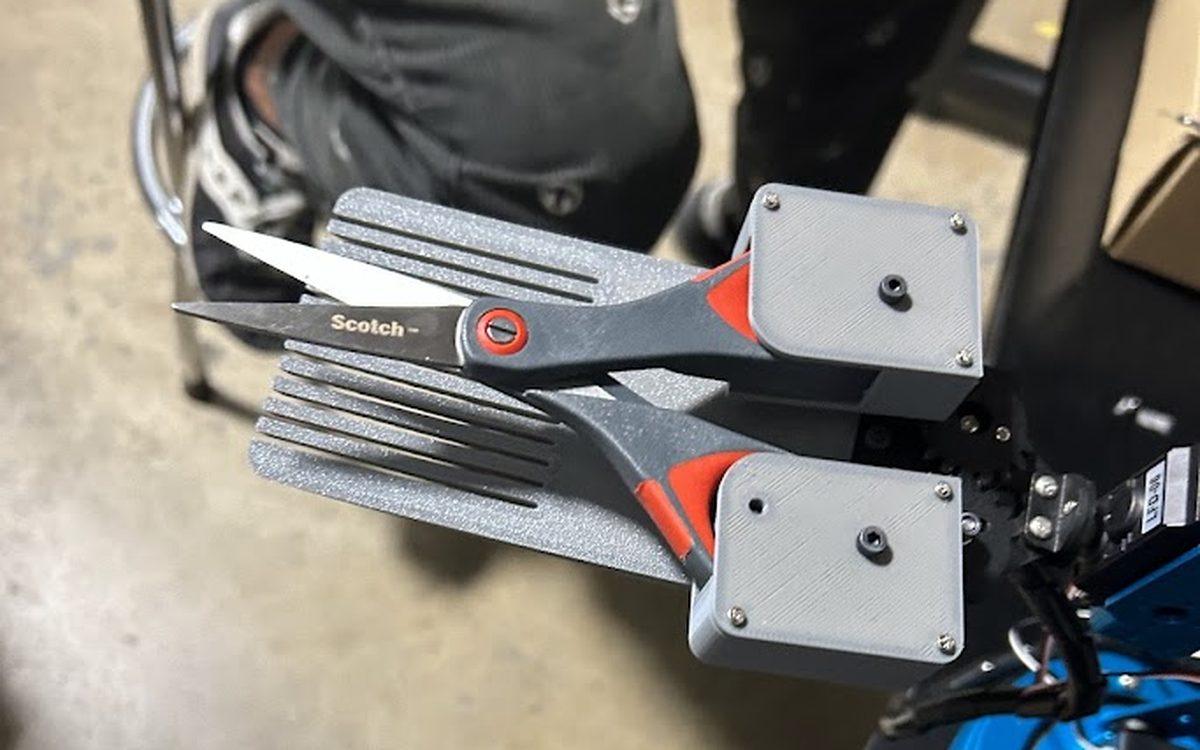 Custom 3D printed robot gripper jaws holding scissors, robotics engineering